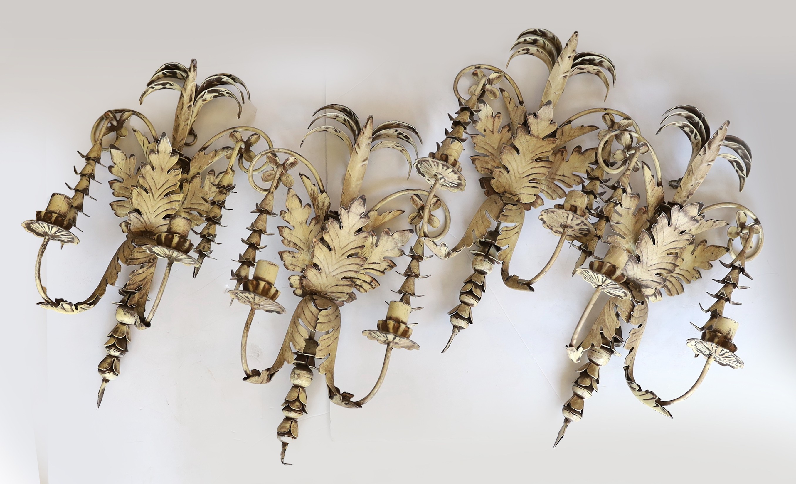 A set of four French white painted metal twin branch wall lights of foliate design, height 50cm. width 28 cm